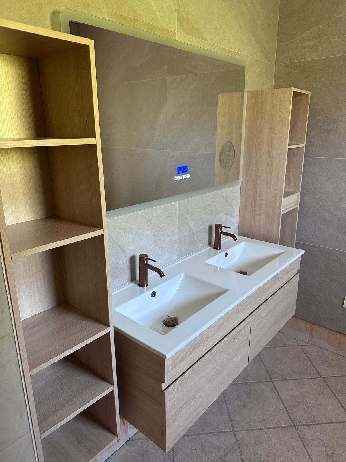 Double vasque blanche, meubles en bois clair et robinetterie posés par Passalacqua Plomberie.